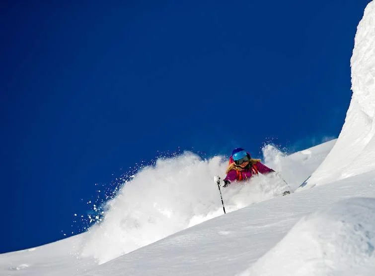 Skier descending a powder-covered slope in Alaska
